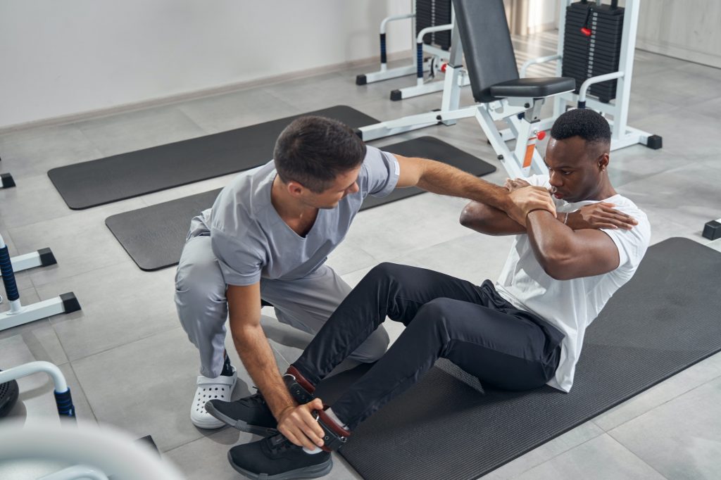 Qualified physiotherapist assessing muscle strength of patient