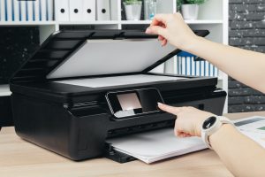 Woman making photocopy using copier in office