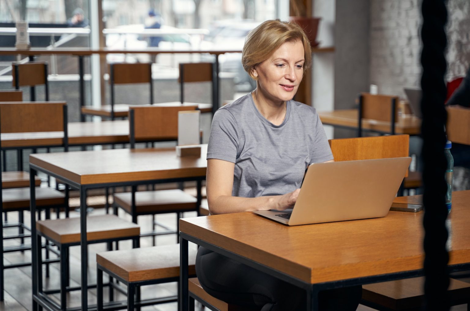 Woman working on modem laptop in cafeteria